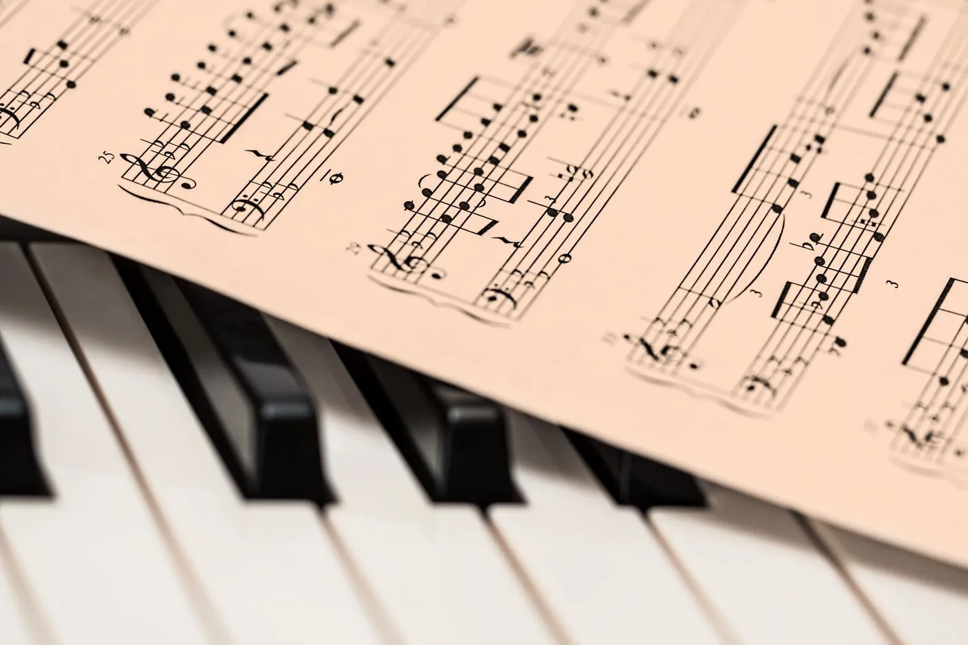 Printed music score resting across piano keys